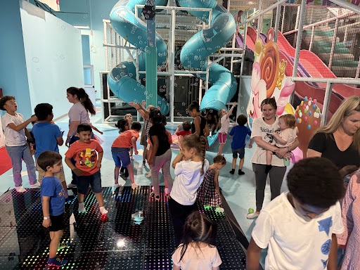 Kids dancing on the interactive LED floor during a bubble party at Hyper Kidz Katy indoor playground