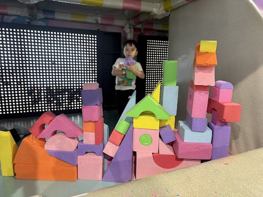 A child building with large foam blocks at Hyper Kidz Katy indoor playground